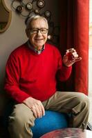 A senior man in a red sweater relaxing photo