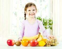 pequeño niña con frutas para salud y bienestar concepto foto