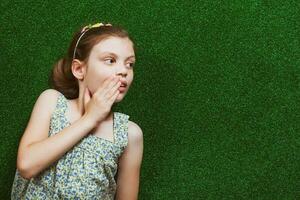 Little girl is lying on artificial grass photo