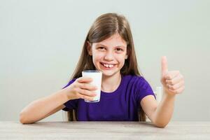 un niña Bebiendo Leche foto