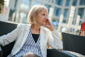 A senior businesswoman sitting at a cafe photo