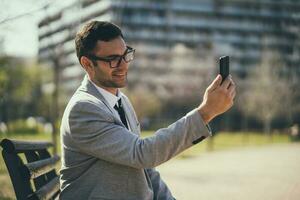 A businessman sitting on a park bench photo