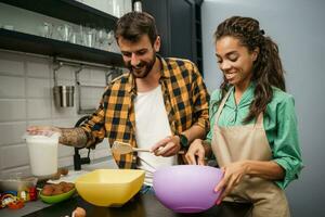 Happy multiethnic couple cooking together photo