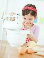 un joven niña Cocinando foto