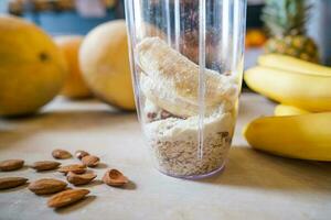 Healthy protein shake on table with fruits and vegetables ingredients around photo