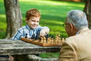 un abuelo y su nieto jugando ajedrez foto