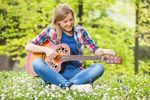 un mujer jugando guitarra foto