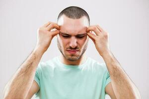 A man with green tshirt having a headache photo