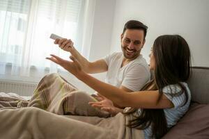 un joven Pareja acostado en cama foto