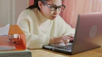 Young Asian woman using smartphone and working sitting in office at home close-up. video