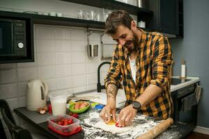 un hombre horneando galletas en el cocina foto