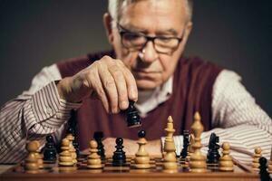 un mayor hombre jugando ajedrez foto