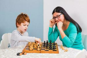 A woman playing chess with a child photo