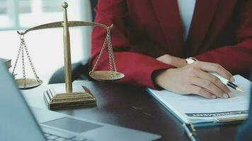 Justice and Law concept. Legal counsel presents to the client a signed contract with gavel and legal law or legal having team meeting at law firm in background video