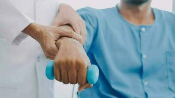 Doctor or Physiotherapist working examining treating injured arm of athlete male patient, stretching and exercise, Doing the Rehabilitation therapy pain in clinic. video