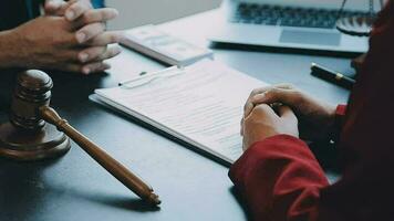 Justice and Law concept. Legal counsel presents to the client a signed contract with gavel and legal law or legal having team meeting at law firm in background video