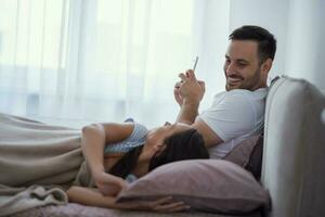 un joven Pareja acostado en cama foto