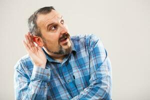 A man with a blue plaid shirt making a face photo