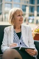 A senior businesswoman sitting at a cafe photo