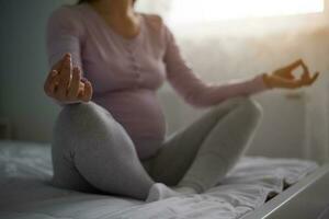 un embarazada mujer meditando foto