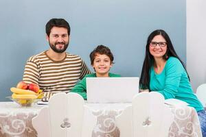 Parents are teaching their son to use the laptop photo