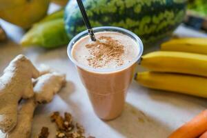 Healthy protein shake on table with fruits and vegetables ingredients around photo