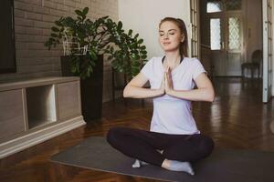 joven mujer practicando pilates y yoga ejercicios a hogar foto