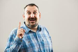 A man with a blue plaid shirt making a face photo