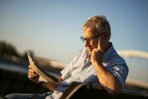 Senior man reading a book outside photo