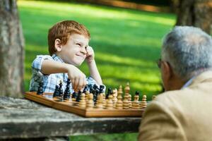 un abuelo y su nieto jugando ajedrez foto