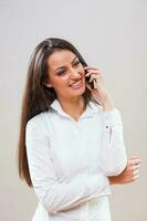 A woman with a white shirt on the phone photo