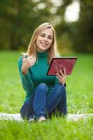 A woman spending time outdoors with a tablet device photo