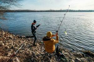 padre y hijo son pescar en soleado invierno día foto