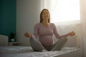 un embarazada mujer haciendo yoga foto