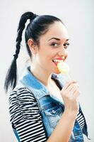 un mujer comiendo un pirulí foto