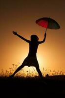 Silhouette of a woman with umbrella over the sunset photo