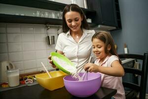 madre e hija cocinando juntas foto