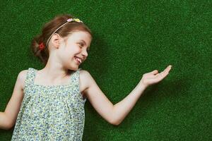 Little girl is lying on artificial grass photo