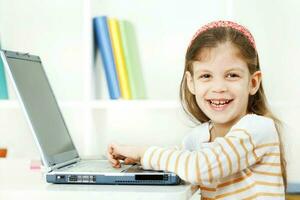 un niña utilizando un ordenador portátil foto