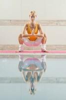 A woman doing physical exercises at the swimming pool photo