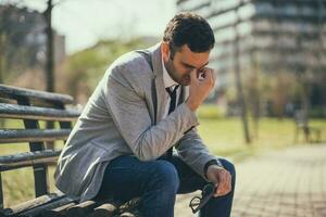 A businessman sitting on a park bench photo