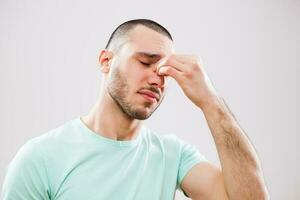 A man with green tshirt having a headache photo