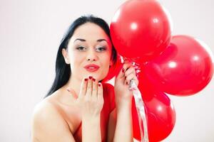 A woman holding red balloons photo