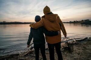 Father and son are fishing on sunny winter day photo