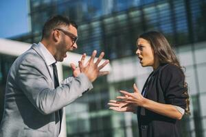 Business colleagues are arguing outside the company building. photo