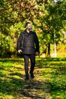 Young man walking on the park during fall photo