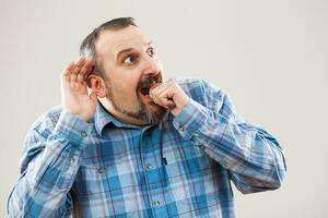 A man with a blue plaid shirt making a face photo