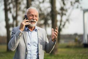 A senior businessman having a phone conversation photo