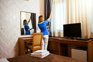 A maid working in a hotel room photo