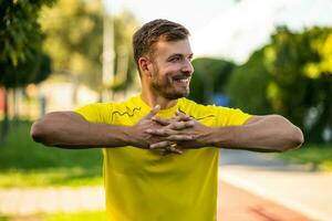 A man in a yellow t-shirt doing physical exercises photo